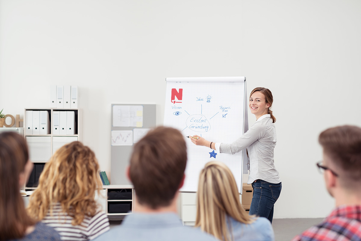 Vrouw geeft een presentatie aan een groep mensen.